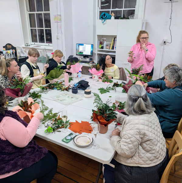 Group of people participating in a floral arrangement workshop.