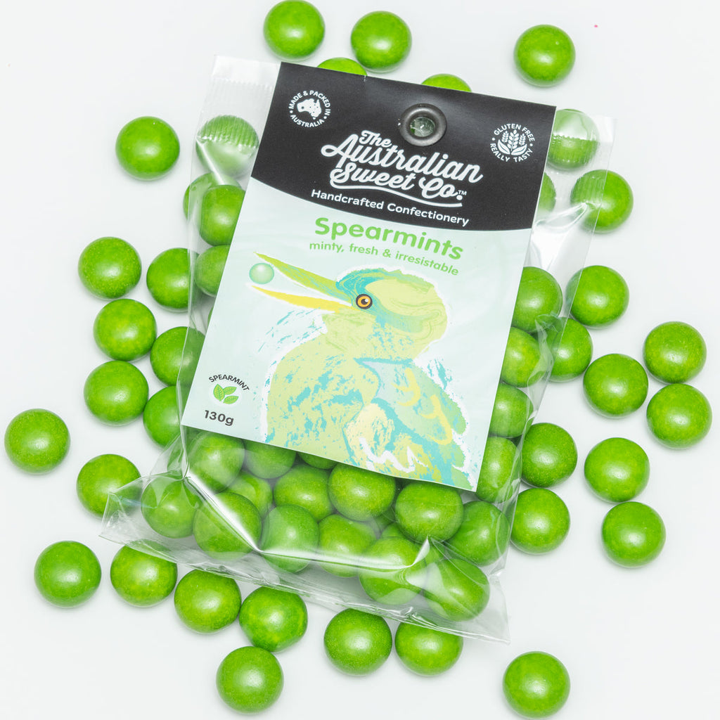 Green spearmint candies with a transparent packaging bag featuring branding on a white background.