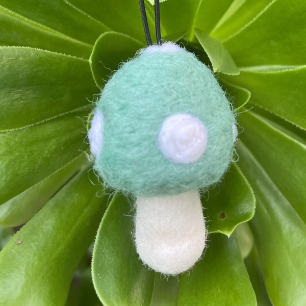 Felted mushroom ornament on green leaves